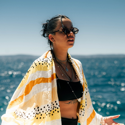 devojka ogrnuta u tackasti na linije zuto belo crni bambus peskir 